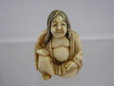 An Antique Oriental Ivory Netsuke, depicting a man crouching on one knee, character marks to base,