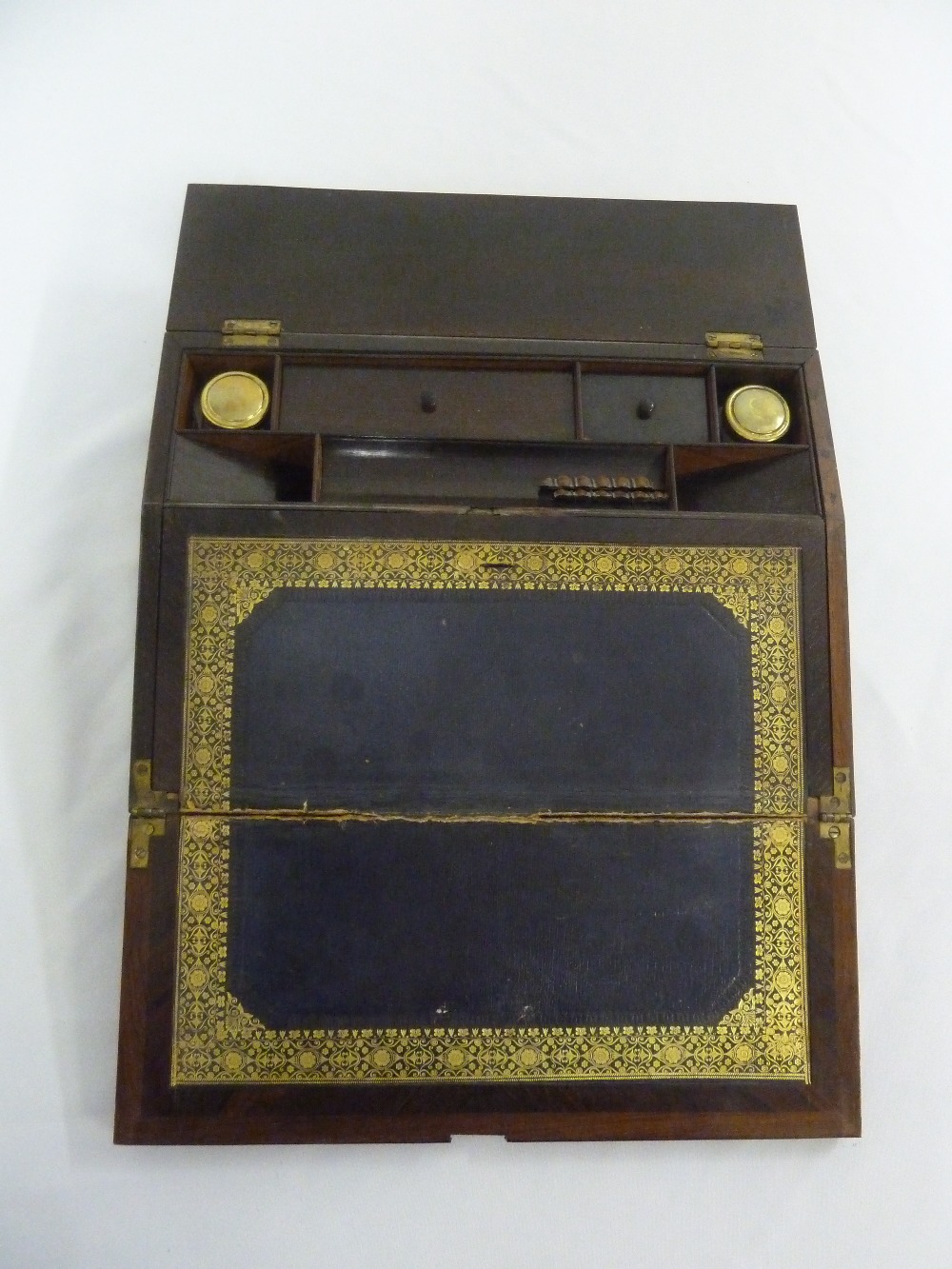 An early 19th century rosewood writing slope with gadrooned borders, the hinged cover inlaid with