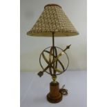 Brass table lamp in the form of a sundial on raised wooden stand with linen shade