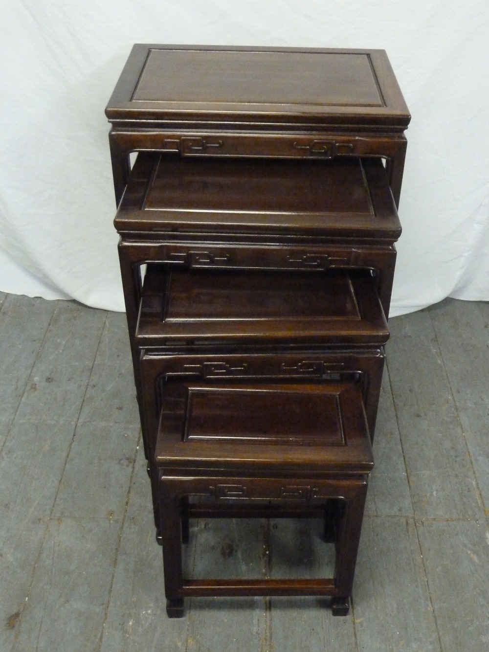 Oriental hardwood nest of four tables, rectangular with stylised carving