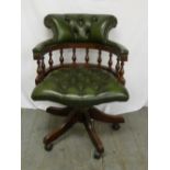A green leather Captains chair on swivel base
