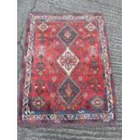 Persian wool carpet, red ground with geometric medallions within geometric border, 145 x 111cm