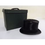 A silk top hat by Henry Heath of London with accompanying carrying case