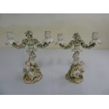 Pair of Continental Rococo style porcelain candelabra decorated with putti figurines, flower and