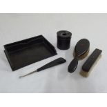 A quantity of ebony to include a desk tidy, a cotton wool holder, two brushes and a shoe horn