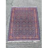 Persian wool carpet, geometric forms predominantly dark red and dark blue, 131 x 108cm