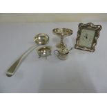 A quantity of silver to include a ladle, a bonbon dish, condiments and a silver mounted desk clock