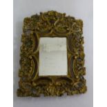 A carved and pierced gilt wood table mirror with hinged back strut A/F