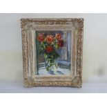 A framed oil on canvas still life of roses in a vase indistinctly signed bottom right, 41.5 x 34.