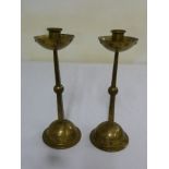 A pair of WMF Arts and Crafts spot hammered brass candlesticks on raised domed bases, marks to the