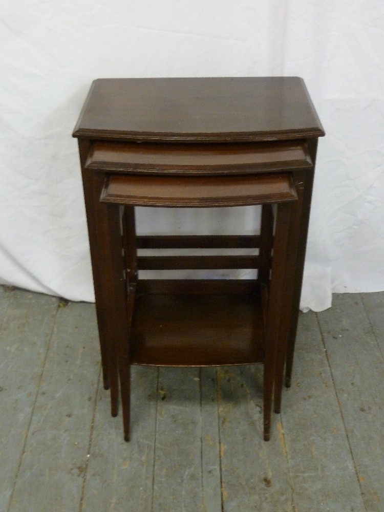 A mahogany nest of three tables on tapering legs