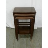 A mahogany nest of three tables on tapering legs