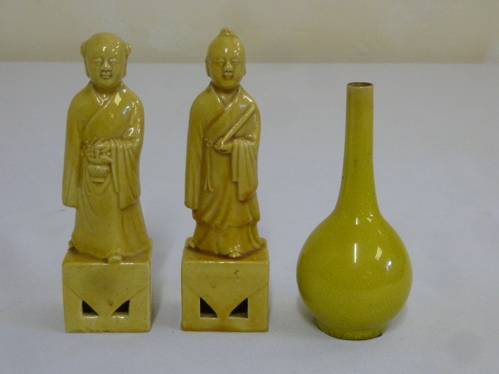 A pair of 19th century yellow glazed figurines and a yellow glazed vase