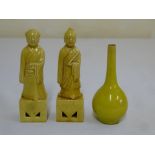 A pair of 19th century yellow glazed figurines and a yellow glazed vase