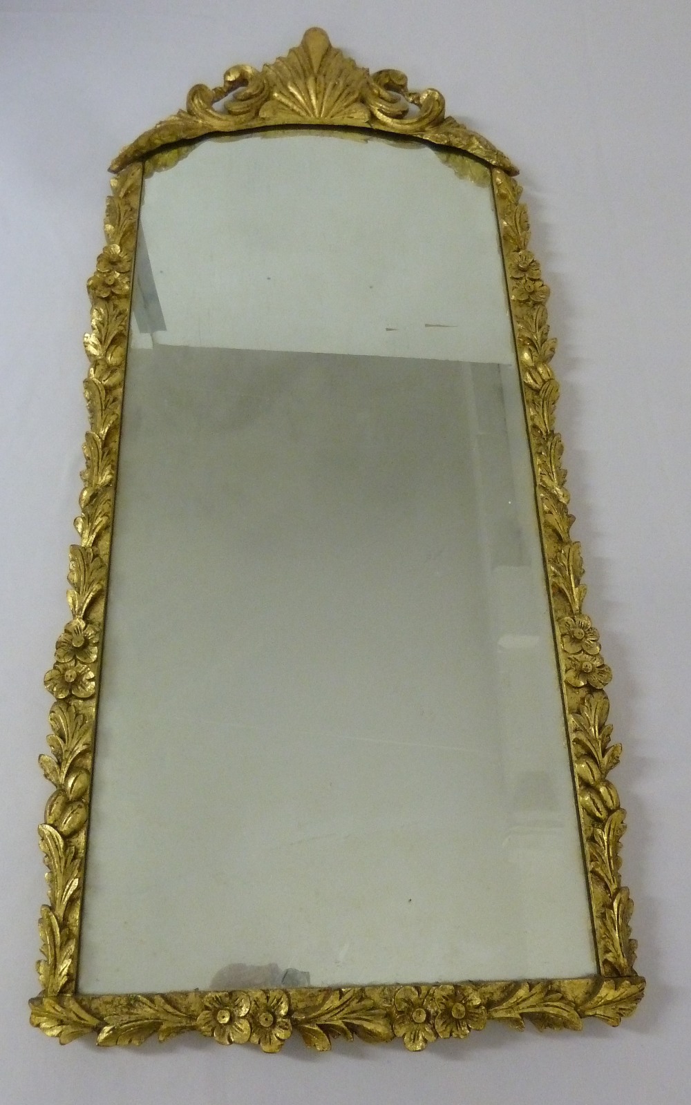 Gilded wall mirror in floral and leaf frame, 111 x 47cm