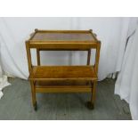 An Art Deco walnut tea trolley of rectangular form with original castors