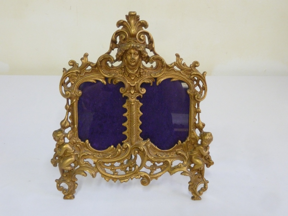 A Victorian gilt metal double picture frame on easel stand