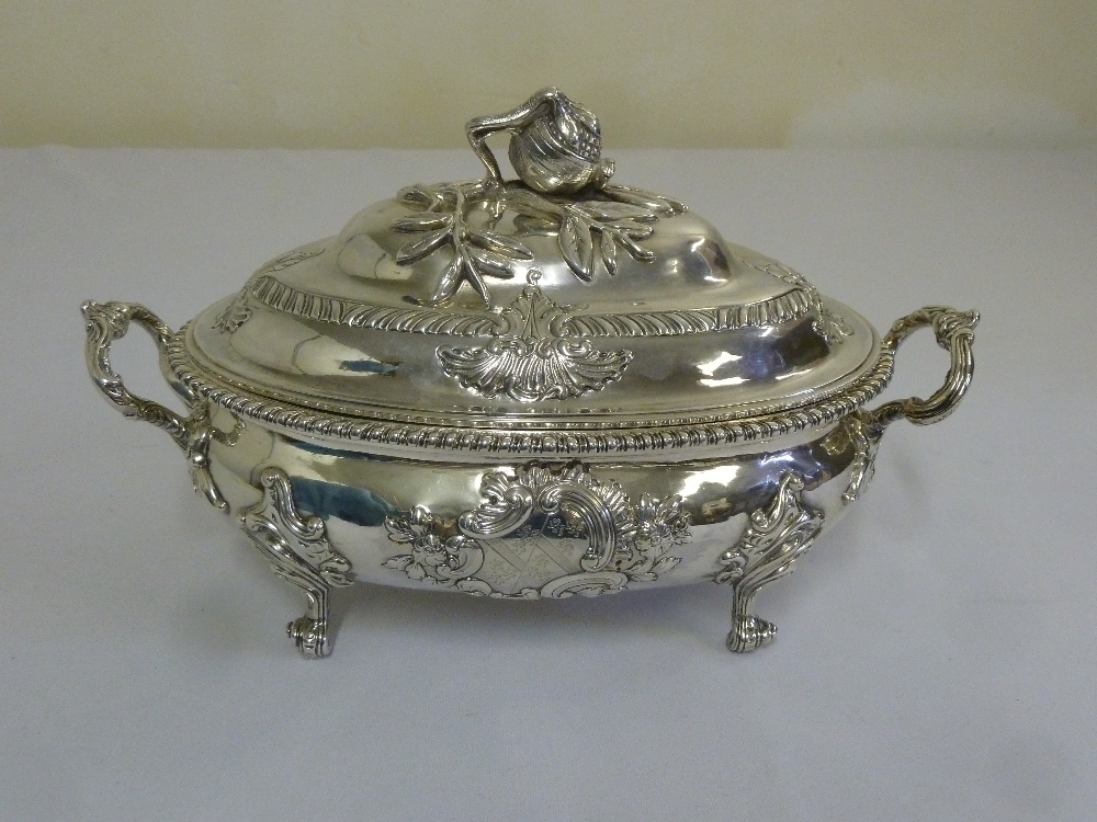 A George III silver tureen and cover, oval with gadrooned border, two leaf mounted pierced scroll