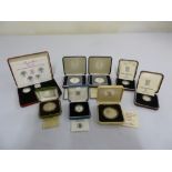 A quantity of silver coins in fitted boxes to include some proof coins (8)