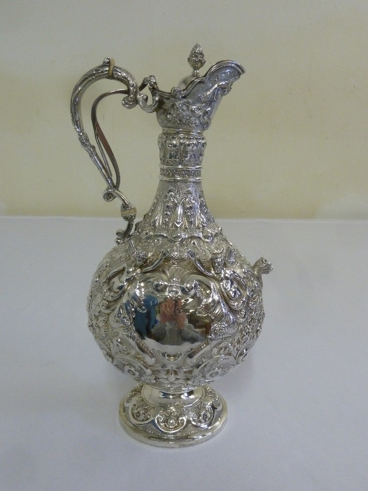 An Edwardian Armada pattern silver claret jug, pear shaped, profusely decorated with figures,