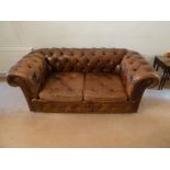 Brown leather two seater Chesterfield on castors