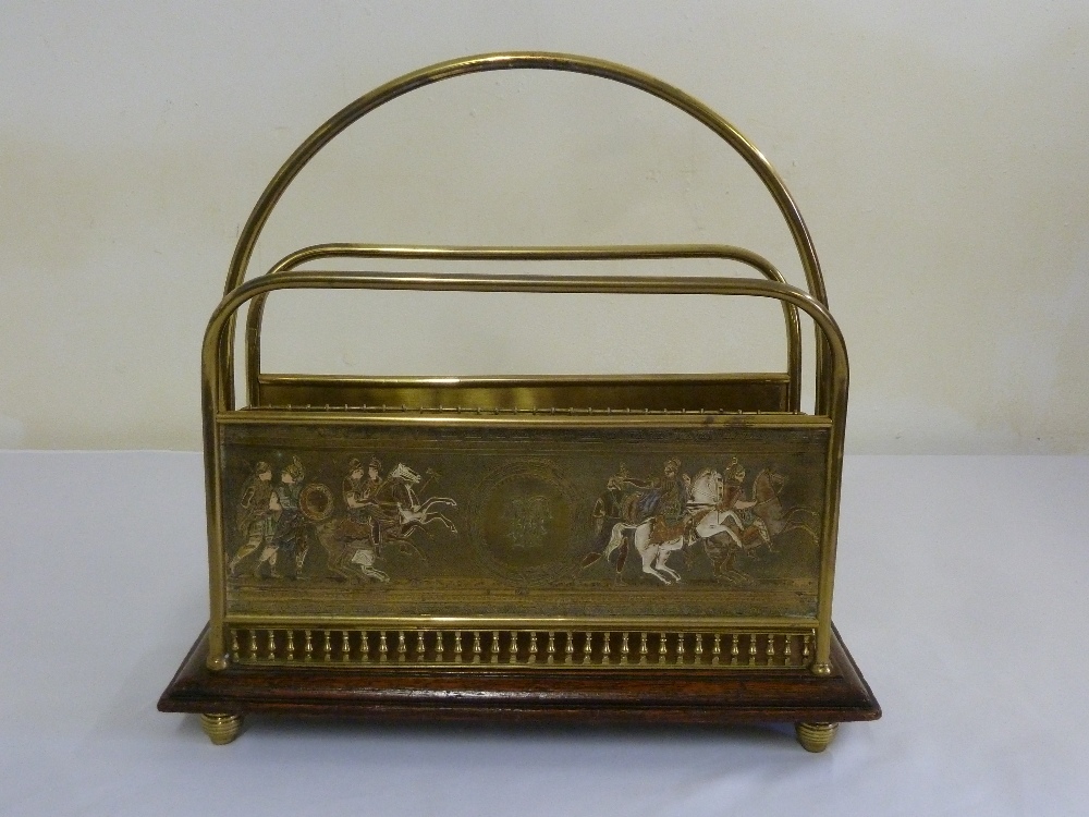 A Victorian brass magazine rack mounted on raised wooden base with decorative side panels