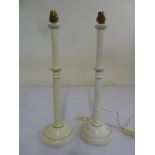 A pair of painted wooden candlesticks of knopped tubular form on raised circular bases converted