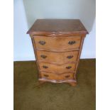 A rectangular mahogany bow fronted chest of drawers with brass handles on four bracket feet