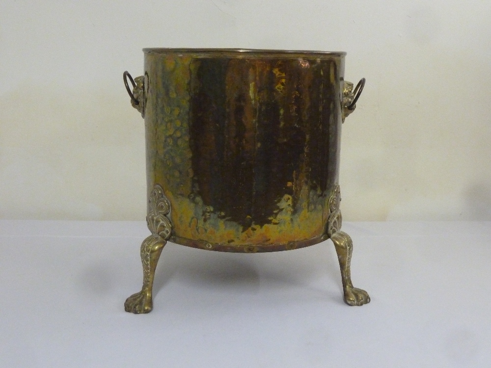 A Victorian cylindrical brass coal scuttle on three scroll legs