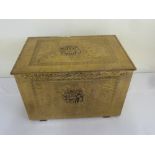 A hand hammered rectangular brass chest, decorated with interior scenes to hinged cover and sides