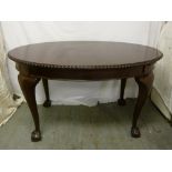 Mahogany dining table with one drop-in leaf on four cabriole legs with ball and claw feet