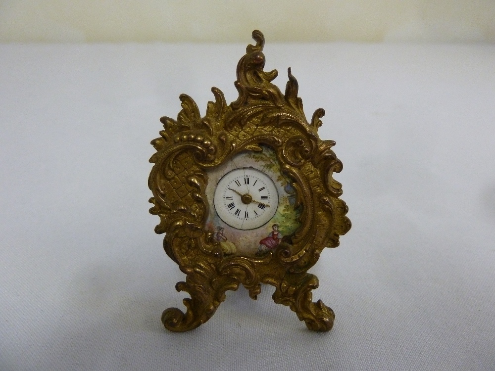 A miniature Viennese enamel clock in a Rococo gilt metal easel frame