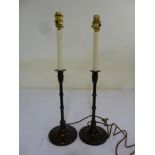 A pair of wooden columnar table candlesticks converted to electric lamps