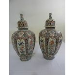 A pair of Chinese famile rose vases the domed pull off covers with dogs of foe finials