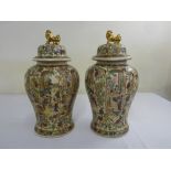 A Chinese famile verte baluster vases profusely decorated with figures, the domed pull off covers