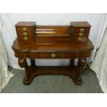 A Victorian mahogany desk shaped rectangular on scrolling legs with brass handles to seven drawers
