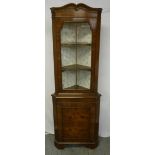 A mahogany corner cabinet with glazed and hinged top section on cupboard base with bracket feet