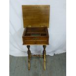A Victorian mahogany sewing table rectangular with two drawers and hinged top on turned scroll