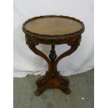 A Continental mahogany occasional table, circular, masked mounted scroll supports on three scrolling