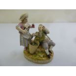 Meissen a figural group of grape pickers on raised circular base, marks to the base, 17cm (h)