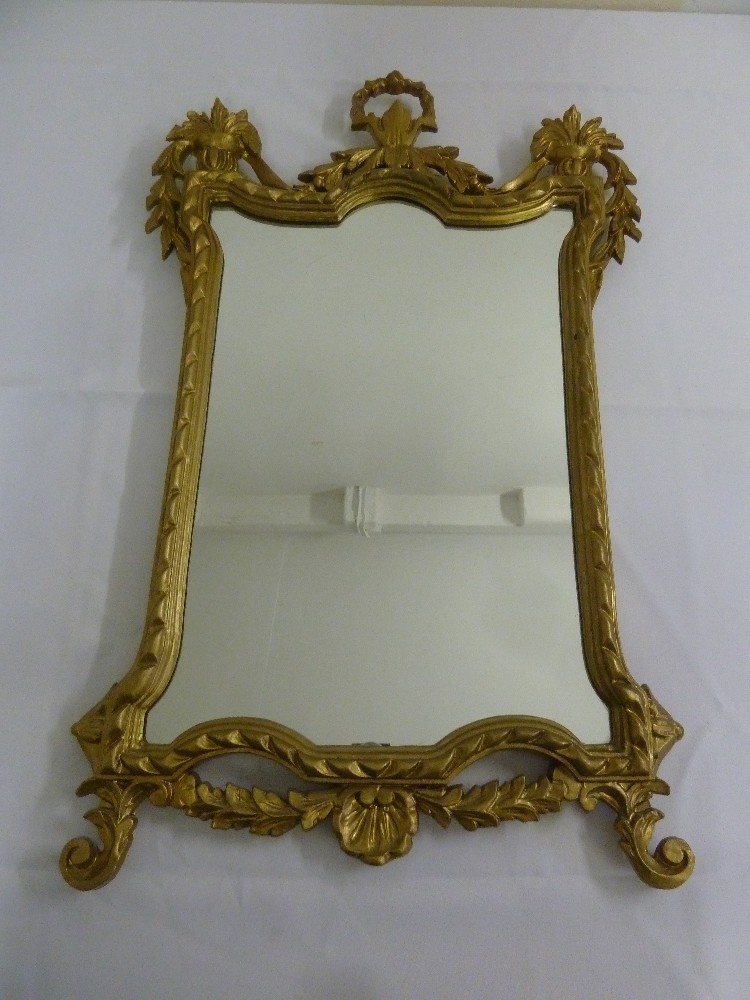 A gilded rectangular wall mirror carved with leaves and scrolls in the French 19th century style