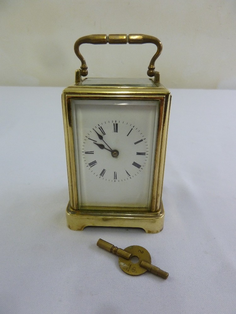 A brass carriage clock of customary form, to include key