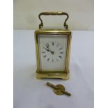 A brass carriage clock of customary form, to include key