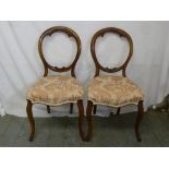 A pair of mahogany balloon back upholstered chairs on cabriole legs