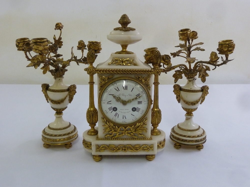 A French Le Roy 19th century ormolu and white marble mantle clock, flanked by vase form garnitures