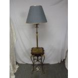 A brass standard lamp with mahogany and brass mounts to the base with four scroll legs with shade