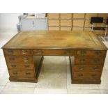 A mahogany reproduction partners desk with tooled leather top, the drawers with brass swing handles