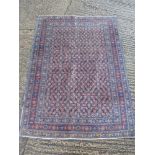 A Persian wool carpet blue ground with geometric repeating patterns and border, 196 x 144cm