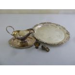 A quantity of silver plate to include a circular tray with vine border, a sauce boat and a silver