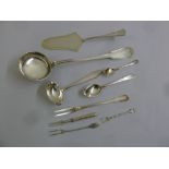 A quantity of silver and white metal flatware to include a ladle, a cake slice, spoons and forks (